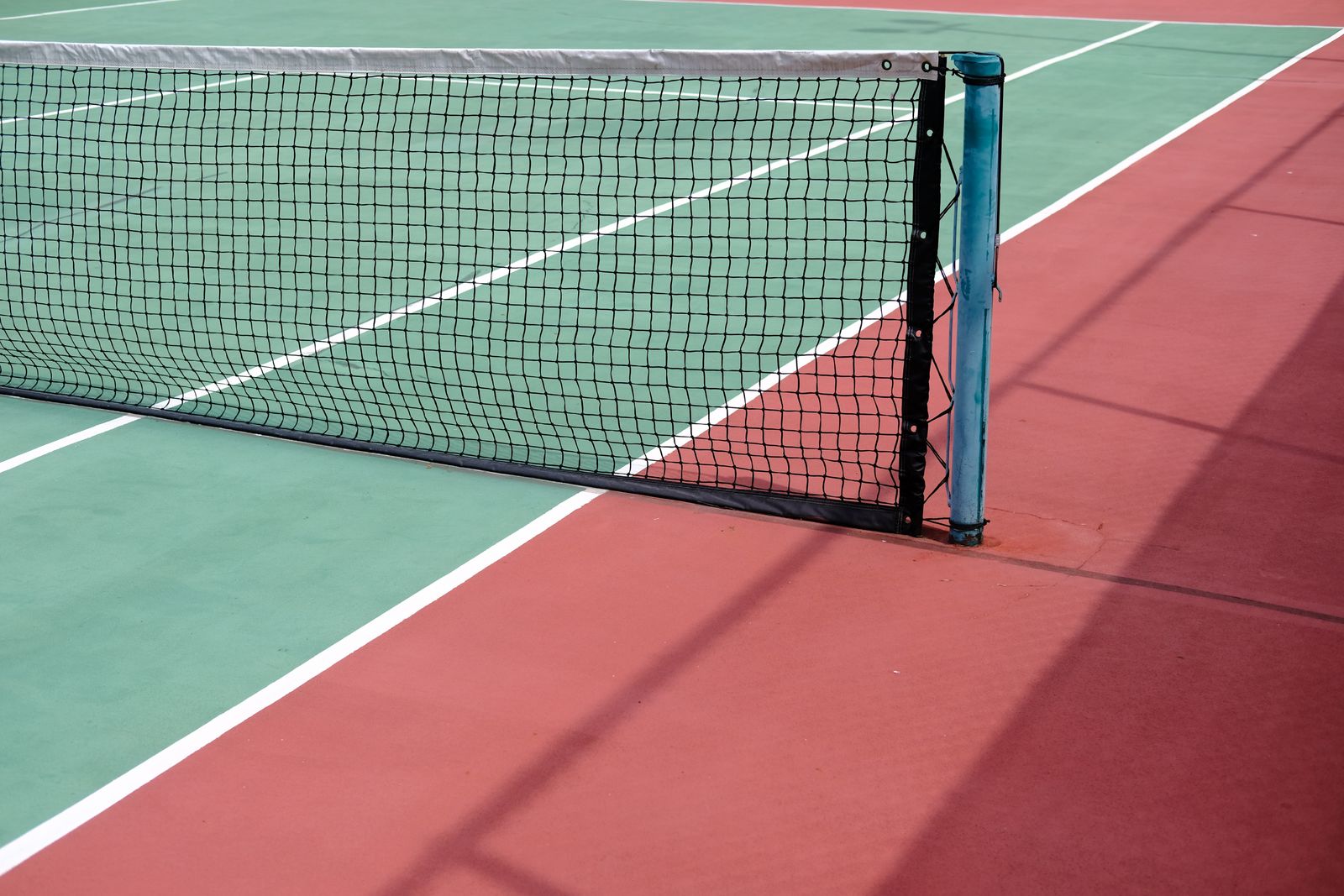 A tennis court net and posts in good condition